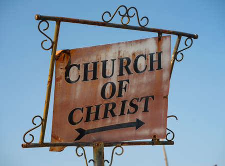 A vintage old rusted metal sign shows the way to the local congregation of Christの写真素材