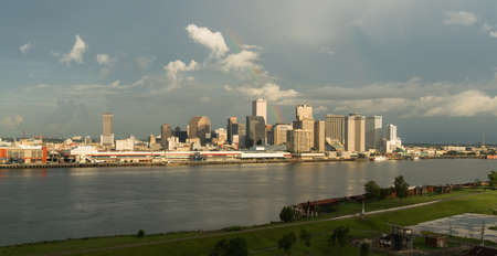 The Mississippi River flows by the New Orleans waterfront storm clearing rainbow glowingの写真素材