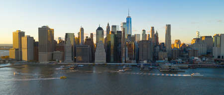 The East River carries boat and ferry traffic into Manhattan on the eastern side at sunsetの写真素材