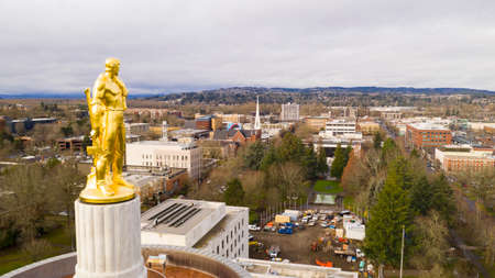 The state capital building adorned with the Oregon Pioneer with downtown Salem in the backgroundのeditorial素材
