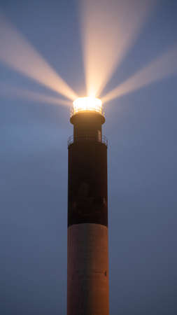 Strong light beams mark the shore for seafarers and islanders at Fort Caswell Lighthouse on Oak Islandの写真素材