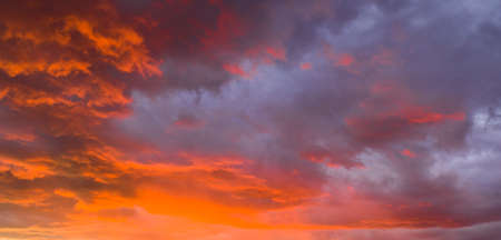 The sun gives up her last light of the day awash over the cloudsの写真素材