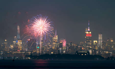 Fireworks are being set off from barges on the river between Jersey City and New York.の写真素材