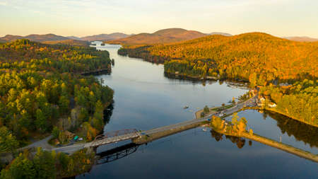 The leaves are changing in Autumn along the lake and on the mountaintops at Long Lakeの写真素材