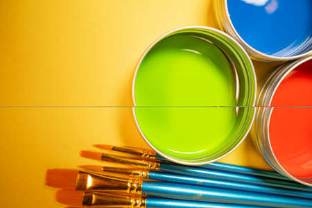 Primary colors in acrylic paint in metal tins still life art supply  and brushesの写真素材