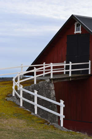 Traditional red barn with hay loft in cloudy weather