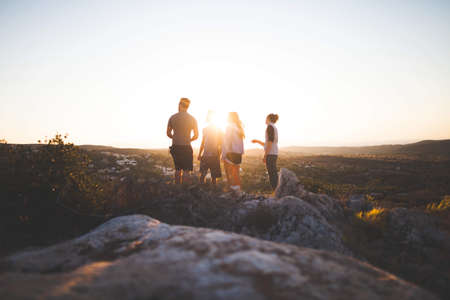 people, friends, group, sunset, dusk, field, rocks, grass, nature, outdoors, adventure, wanderlust