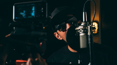 people, guy, singing, music, room, studio, recording, microphone, video, camera, dark, light