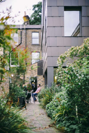 people, man, girls, talking, green, grass, plants, building, house, cafe, pathway