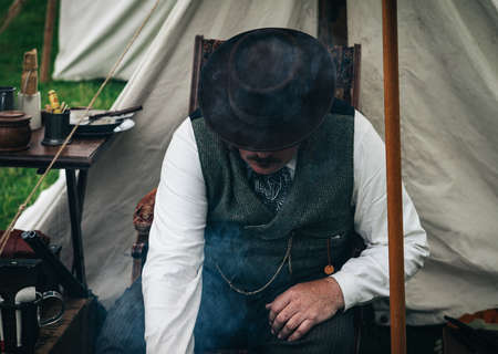 people, man, sitting, camp, field, table, plate, utensils