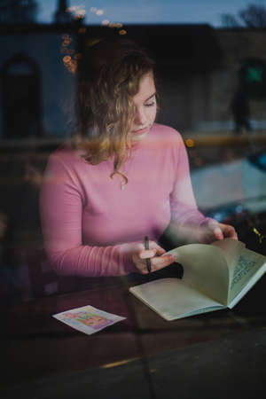 people, girl, writing, paper, pen, notebook, desk, table, bokeh, dark, room