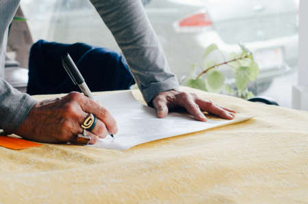 people, man, writing, paper, pen, plan, hand, ring, table, office, work
