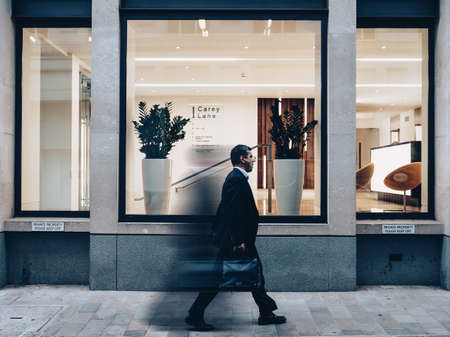 man, guy, walking, glass, window, pane, bag, shop, vase, plant, lights, chair, establishment