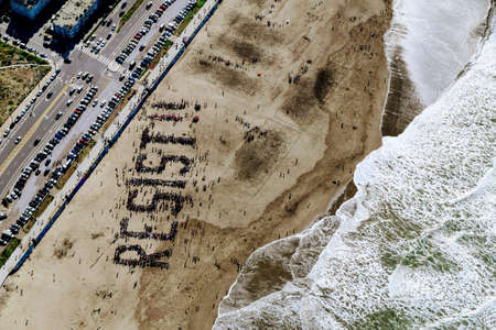 people, rally, unite, resist, protest, beach, ocean, sea, waves, aerial, road, highway, car,...