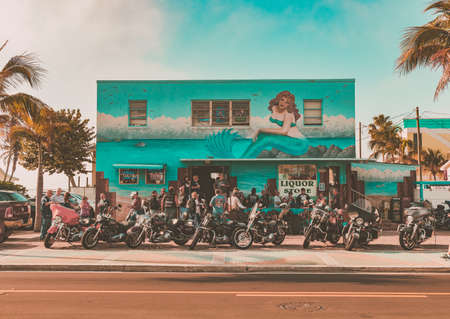 people, men, motorcycle, building, liquor. store, tree, nature, outside, mermaid, paint, travel
