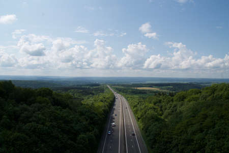 freeway, lane, posts, lights, trees, clouds, sky, vehicle, cars, road, path