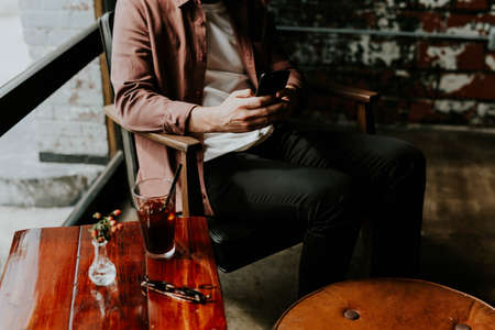 people, man, guy, sitting, wooden, table, sunglasses, flower, vase, furniture, soda, drinks