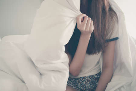 Happiness of young Asian woman lying with blanket on bed in the morning. Winter day. Copy space....