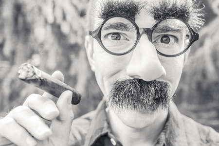 Grayscale Photography of Man Holding Cigar