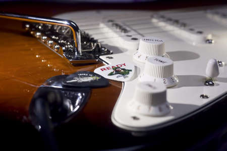 Selective Focus Photo of Brown and White Electric Guitar