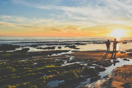 Silhouette Photography of Two Person Standing Near Body of Water