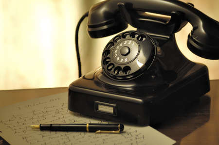 Black Rotary Telephone Beside Ball Pen on White Printed Paper