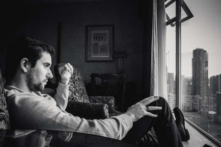 Grayscale Photo of Man Looking at Window