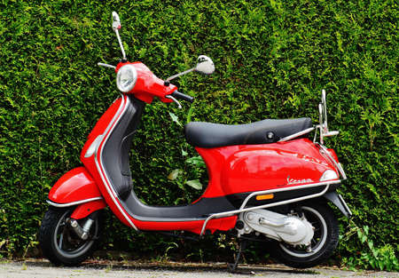 Red and Black Moped Scooter Beside Green Grass
