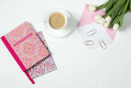 Brown Latte in Ceramic Mug Near Pink and White Floral Textile and White Tulips