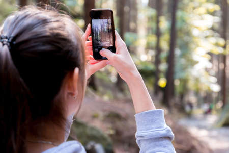 Woman Using Her Smartphone While Taking the Picture the Forest