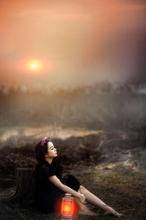 Woman Sitting Beside Lit Lantern