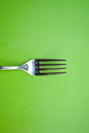 Stainless Steel Fork on Green Paper