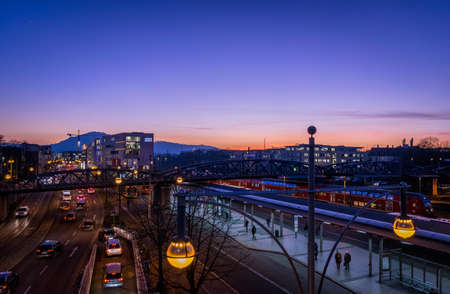 People Walking on Train Station Near Highway in Distant of Buildings