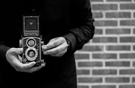 Grayscale Photo of Person Holding Vintage Camera