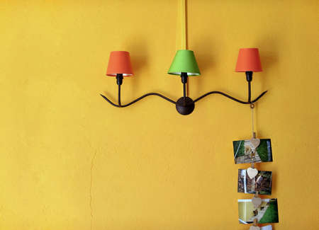 Three decorative lamps with iron holder in yellow wall.の写真素材