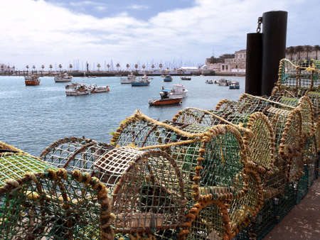 Fishing traps and anchored fishing botes in a port. Cascais, Portugal.の写真素材