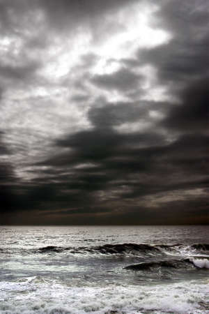 Stormy dark clouds in the sky over troubled ocean.