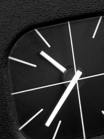Detail of a black watch with minimalist design, on a vehicle's dashboard,