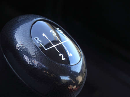 Macro detail of a vehicle's gear stick handle over black backgroundの写真素材