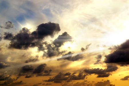 Beautiful cloudy sky with golden sunset and sun beams