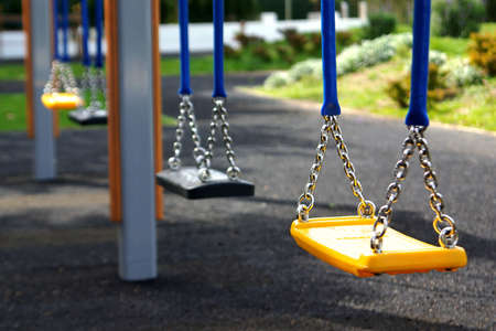 Empty playground swings in a rowの写真素材