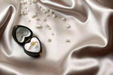 Commitement golden ring in a heart-shaped box over satinの写真素材