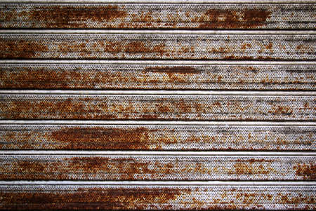 Background photo of a rusty old iron rolling shutterの写真素材