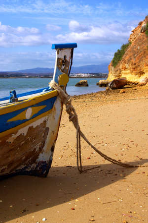 Abandoned fishing boat anchored by the beachの写真素材