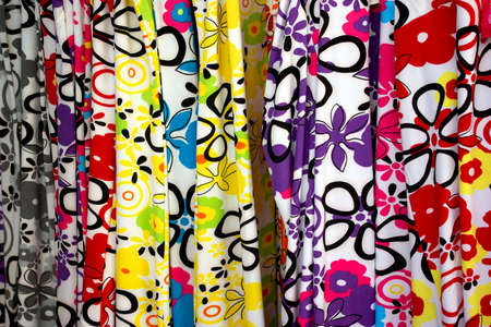Colorful background of hanged fabrics with flowery motifsの写真素材