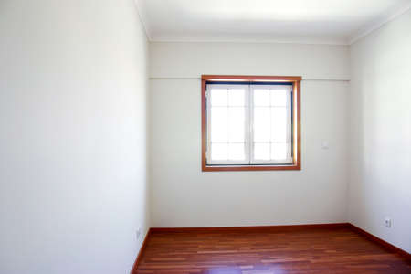 Empty room with a window and white walls in a new house