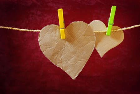 Heart-shaped cardboard pieces hanged in a rope with pinsの写真素材