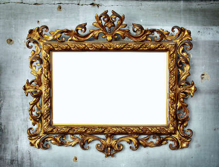 Beautiful golden baroque frame hanged in an old wall with holes and cracksの写真素材