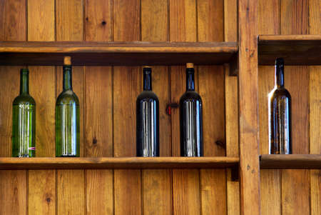 Five wine bottles without label in an old wooden shelfの写真素材