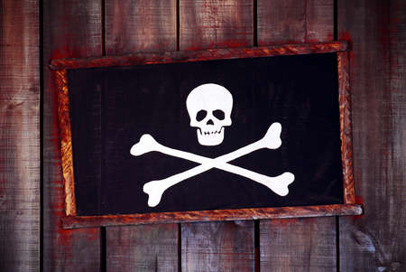 Framed pirate flag hanged in an old wooden wall の写真素材
